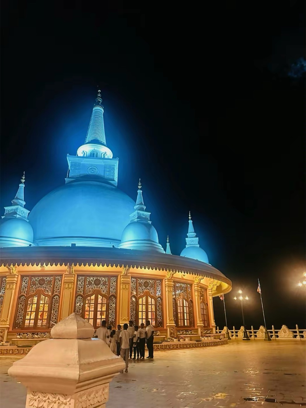 A stupa lit blue at night